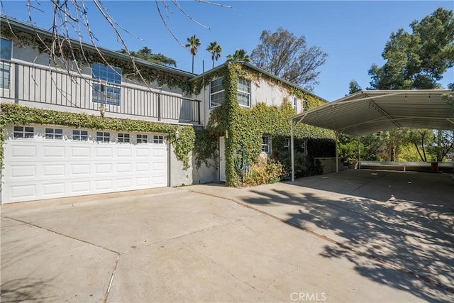 view of front of house with a garage, a carport, concrete driveway, and stucco siding