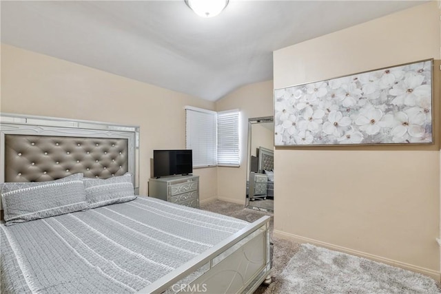 carpeted bedroom featuring baseboards and vaulted ceiling