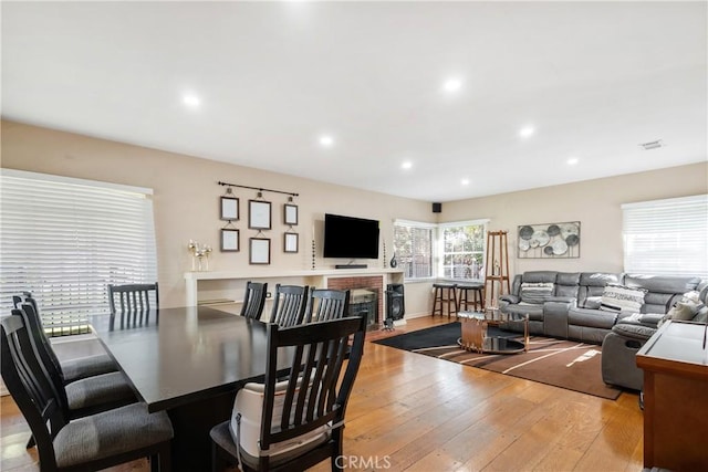 dining room with recessed lighting, visible vents, a fireplace, and hardwood / wood-style flooring