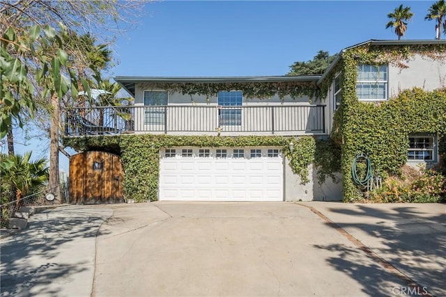 view of front of house featuring driveway, an attached garage, and stucco siding