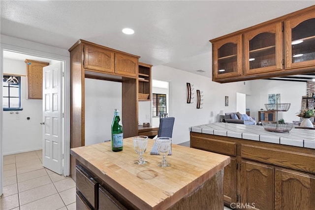 kitchen with light tile patterned flooring, tile countertops, and a center island