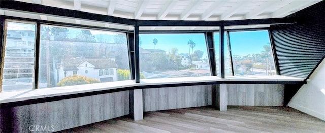 unfurnished sunroom with a healthy amount of sunlight and beamed ceiling