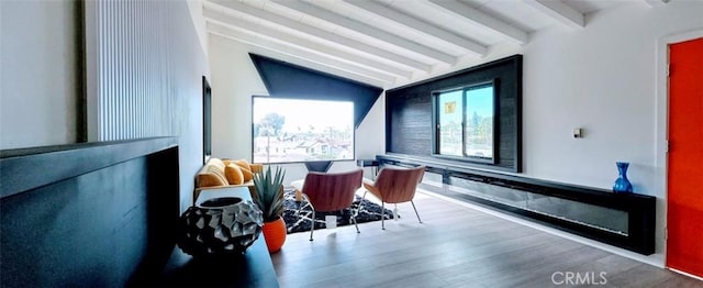 living area with lofted ceiling with beams and wood finished floors