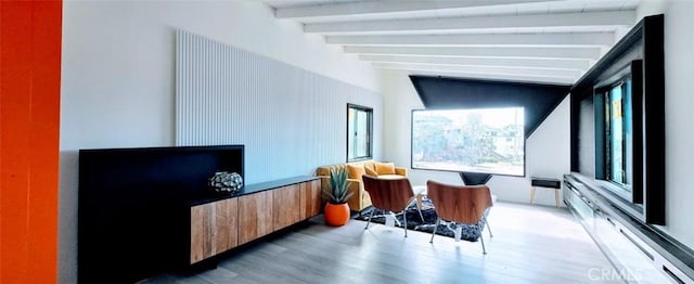 living area featuring lofted ceiling with beams and wood finished floors