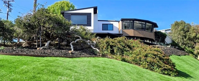 exterior space with stucco siding and a front lawn
