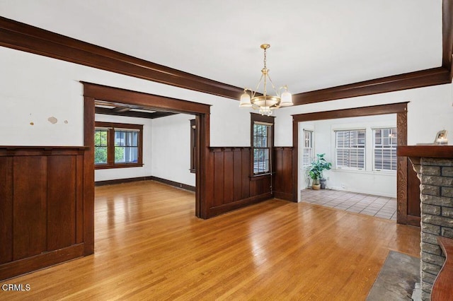 interior space with a fireplace, a chandelier, and light hardwood / wood-style floors