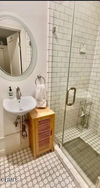 bathroom with sink and a shower with shower door