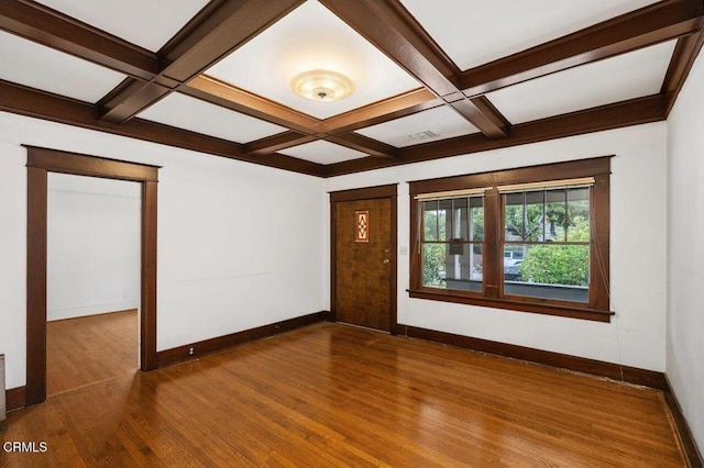 spare room with coffered ceiling, hardwood / wood-style floors, and beam ceiling