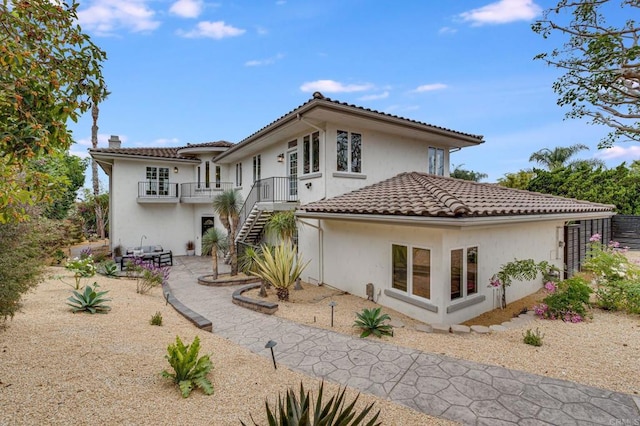 back of property featuring a balcony and a patio area