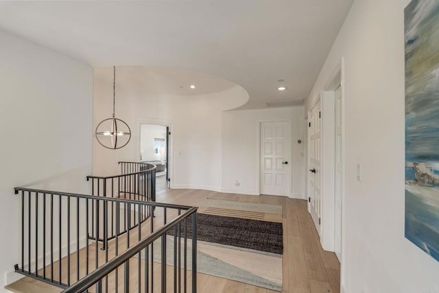 corridor with baseboards, recessed lighting, a notable chandelier, an upstairs landing, and wood finished floors