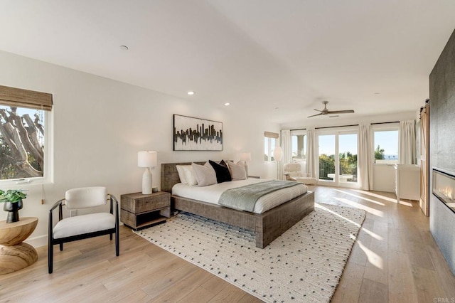 bedroom featuring light wood-style flooring, recessed lighting, and access to exterior