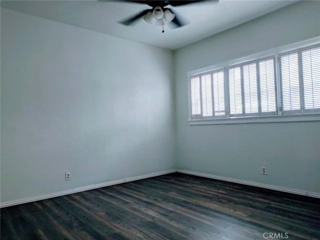 empty room featuring dark wood-type flooring and ceiling fan