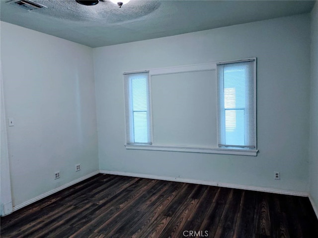 unfurnished room featuring dark hardwood / wood-style floors and a textured ceiling