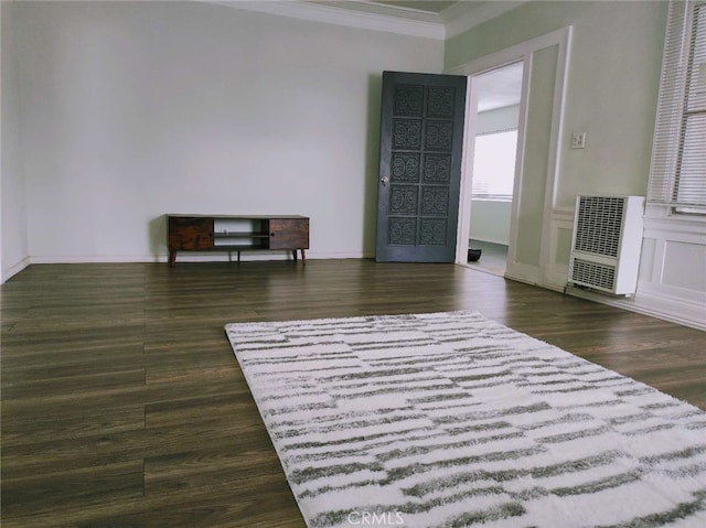 interior space featuring dark hardwood / wood-style flooring, crown molding, and heating unit