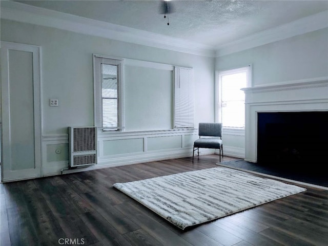 unfurnished room featuring ornamental molding, dark hardwood / wood-style floors, heating unit, and a textured ceiling