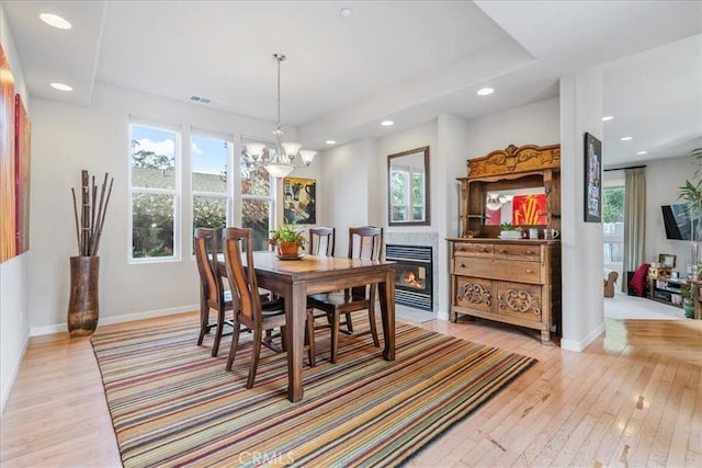 dining area with an inviting chandelier, light hardwood / wood-style flooring, and a healthy amount of sunlight