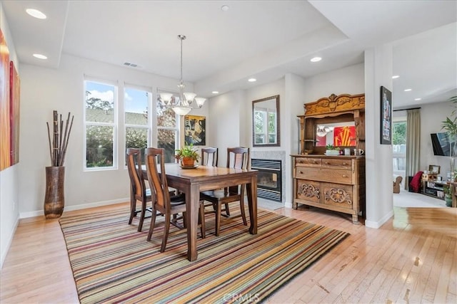 dining space with a notable chandelier and light wood-type flooring