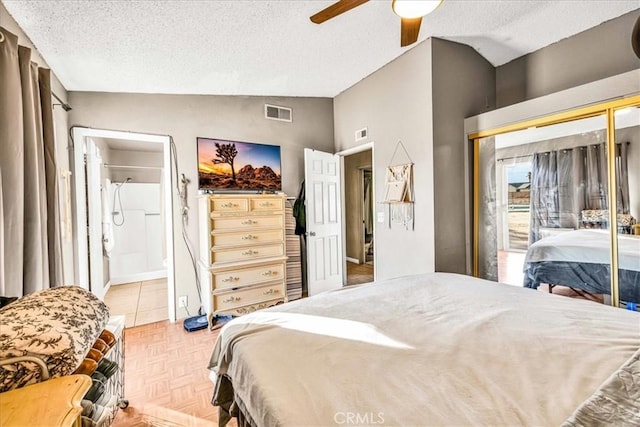 bedroom with light parquet flooring, lofted ceiling, ceiling fan, and a textured ceiling