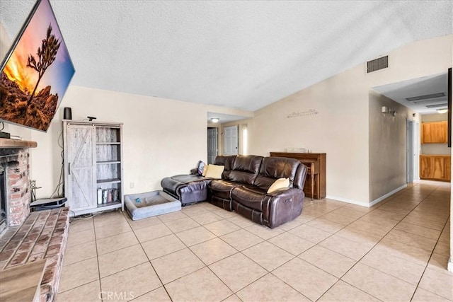 living room with vaulted ceiling, light tile patterned floors, and a textured ceiling