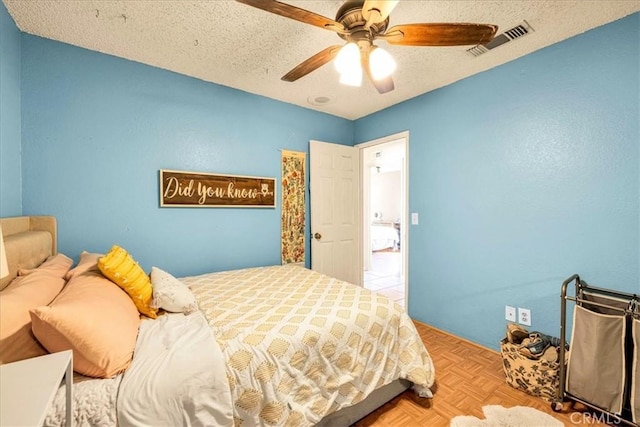 bedroom with ceiling fan, a textured ceiling, and light parquet flooring