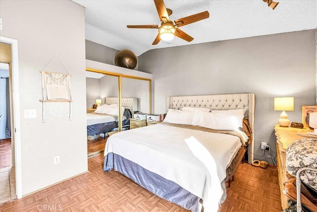 bedroom with light parquet flooring, vaulted ceiling, a closet, and a textured ceiling