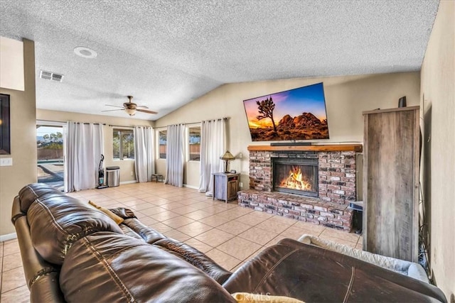 tiled living room with ceiling fan, vaulted ceiling, a brick fireplace, and a textured ceiling