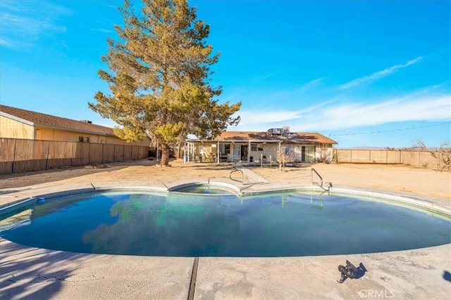 view of swimming pool featuring a patio area and an in ground hot tub