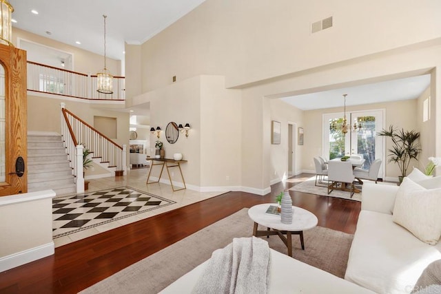 living room with a high ceiling, hardwood / wood-style floors, and an inviting chandelier