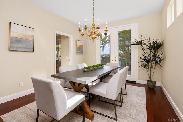 dining area featuring dark hardwood / wood-style flooring, a wealth of natural light, and a chandelier