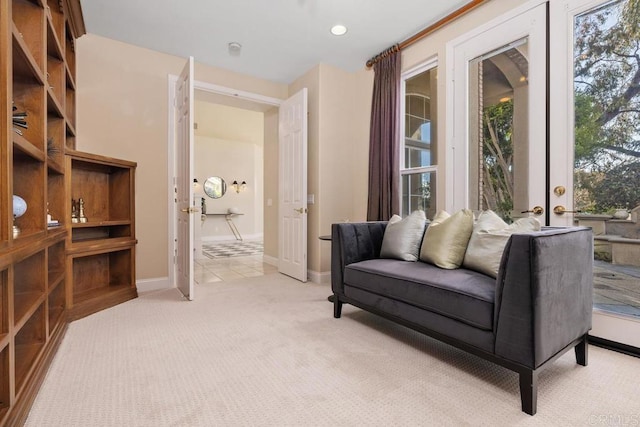 living area with french doors and light colored carpet