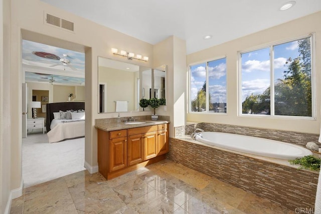 bathroom featuring vanity and tiled bath