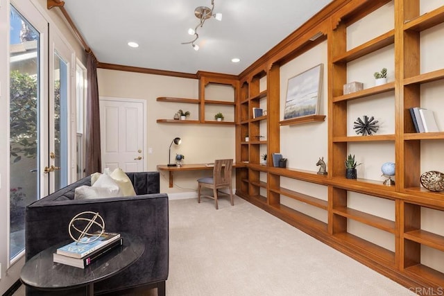 living area featuring crown molding, built in desk, and light colored carpet