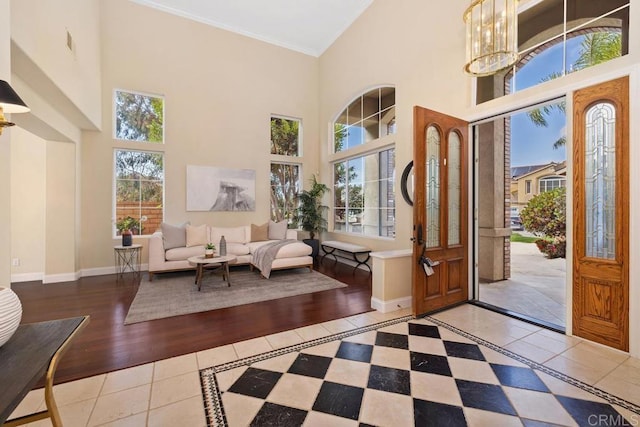 foyer entrance featuring ornamental molding, a high ceiling, and light tile patterned flooring