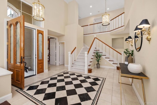 tiled foyer entrance featuring a towering ceiling and a chandelier