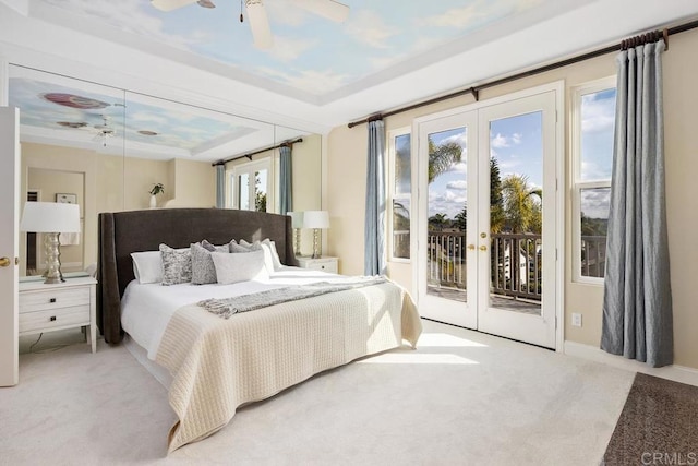 carpeted bedroom featuring a raised ceiling, access to exterior, ceiling fan, and french doors