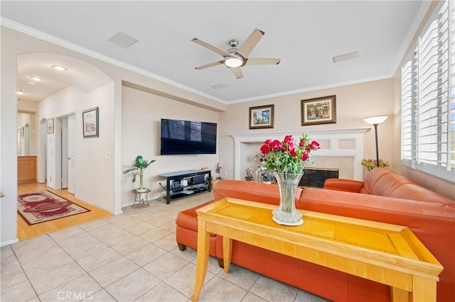 tiled living room featuring crown molding and ceiling fan