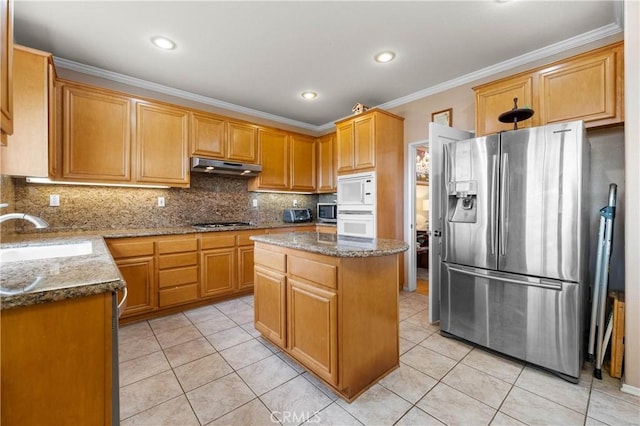 kitchen with a kitchen island, stone countertops, sink, light tile patterned floors, and white appliances