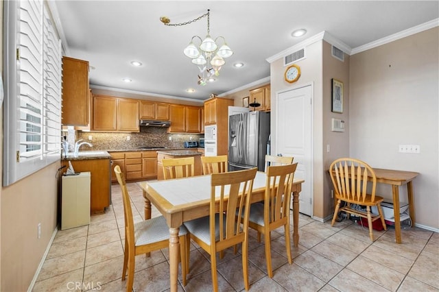 kitchen featuring stainless steel refrigerator with ice dispenser, tasteful backsplash, an inviting chandelier, light tile patterned floors, and a kitchen island