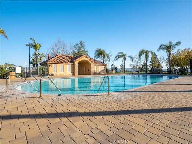 community pool featuring a patio area and fence