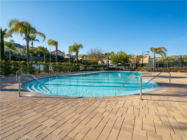 pool featuring a patio and fence