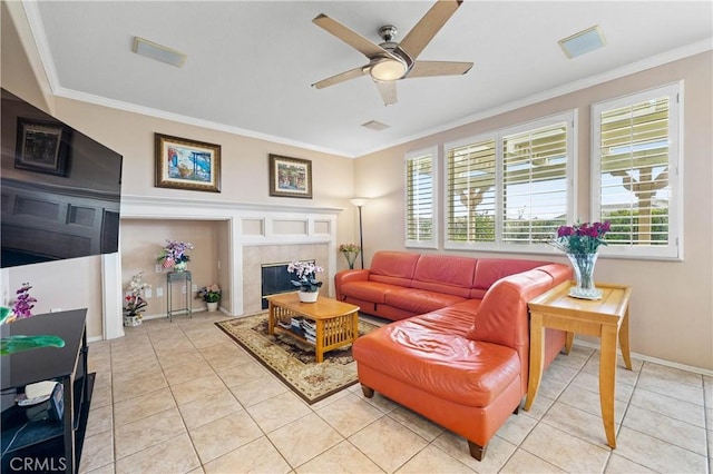 living room with crown molding, light tile patterned floors, a fireplace, and ceiling fan