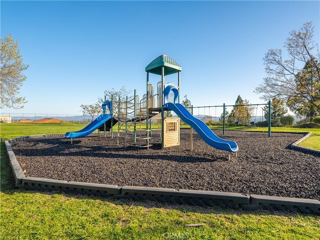 community playground with fence and a lawn