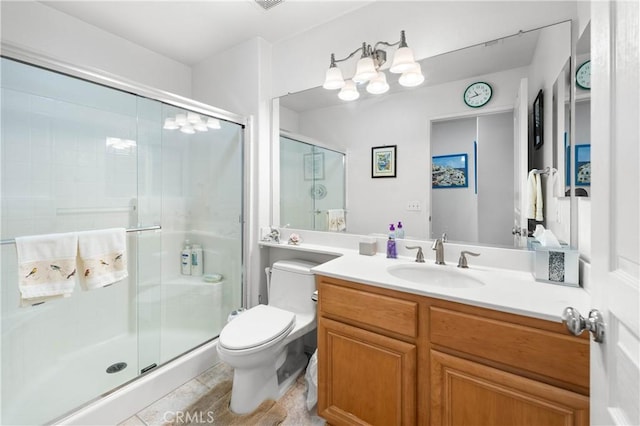 bathroom featuring vanity, toilet, and a shower with shower door