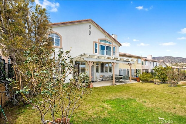 back of property with a patio, a yard, a fenced backyard, a pergola, and stucco siding