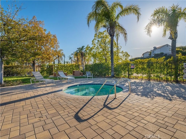 view of pool with a patio area, a community hot tub, and fence