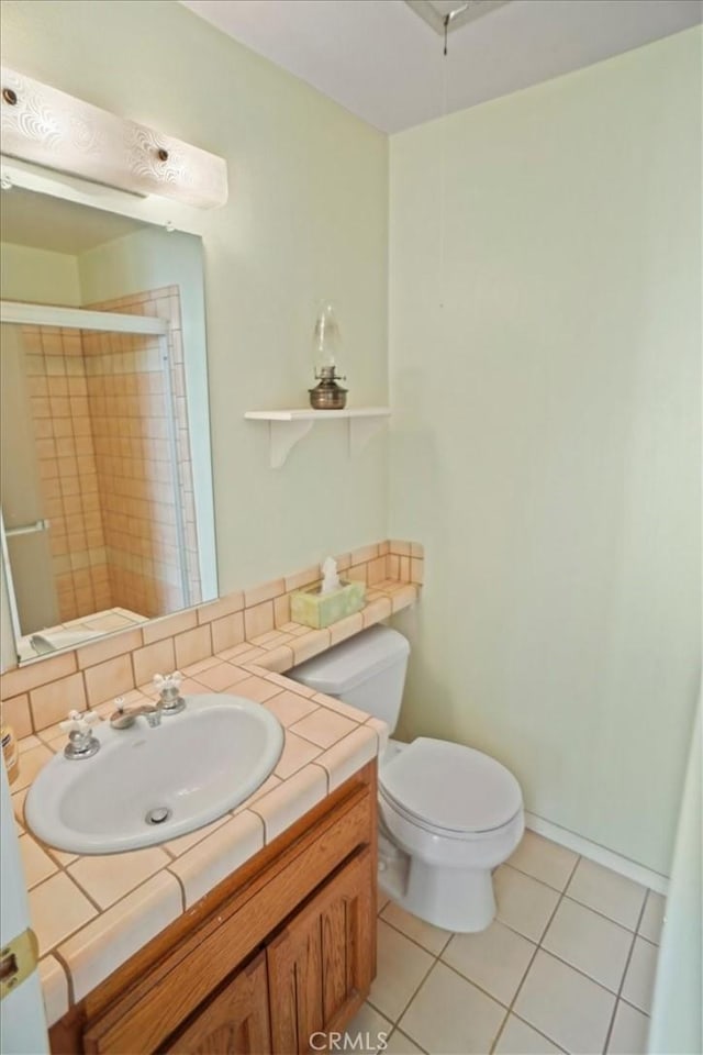 bathroom with tile patterned floors, toilet, vanity, and a shower