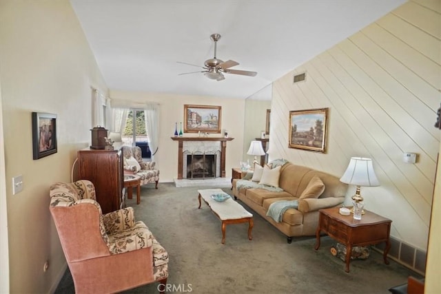 living room featuring vaulted ceiling, a premium fireplace, carpet, and ceiling fan