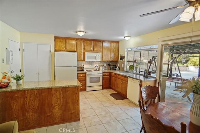 kitchen with sink, light tile patterned floors, kitchen peninsula, white appliances, and decorative backsplash