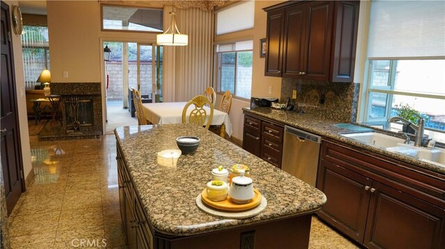 kitchen with pendant lighting, dishwasher, sink, and a kitchen island