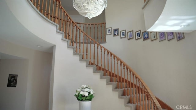 stairway featuring a chandelier and a high ceiling